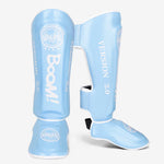 Protège tibias de boxe - bleu clair avec inscription Boom blanche Gingpai - Vignette | SacDeFrappe.fr