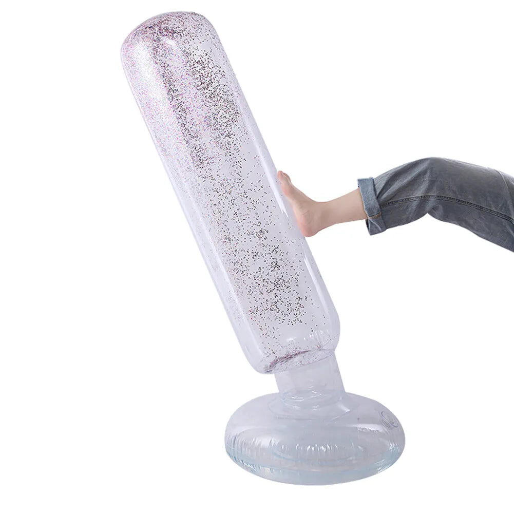 Personne frappant un punching ball gonflable transparent avec des paillettes multicolores, démontrant sa flexibilité et sa capacité à se redresser.