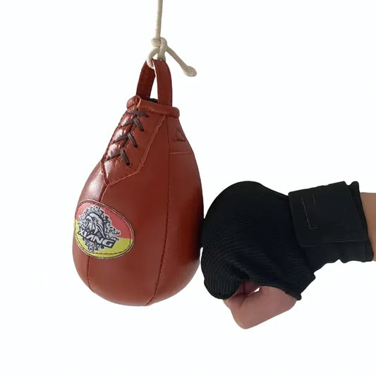 Punching ball en cuir suspendu avec une main en gants frappant.