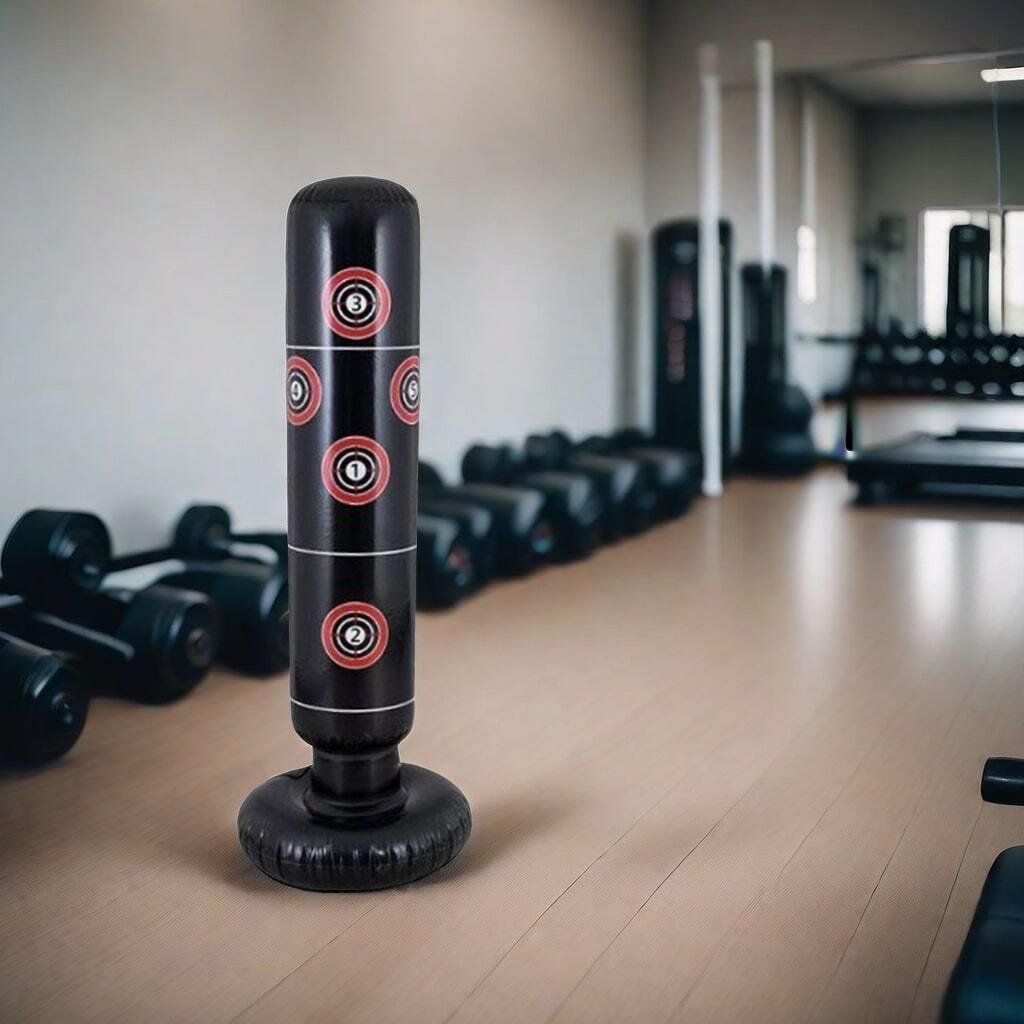 Punching ball gonflable noir avec des cibles rouges et blanches dans une salle de sport, entouré d'haltères et d'autres équipements de fitness