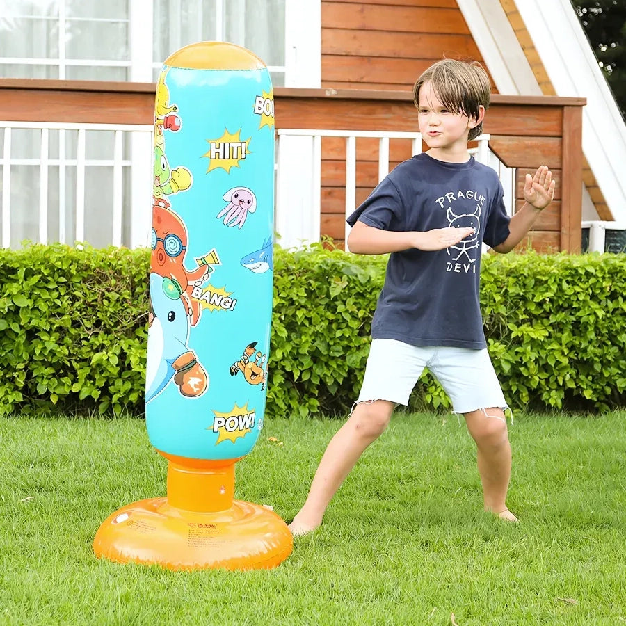 Enfant jouant avec un punching ball gonflable dans le jardin.
