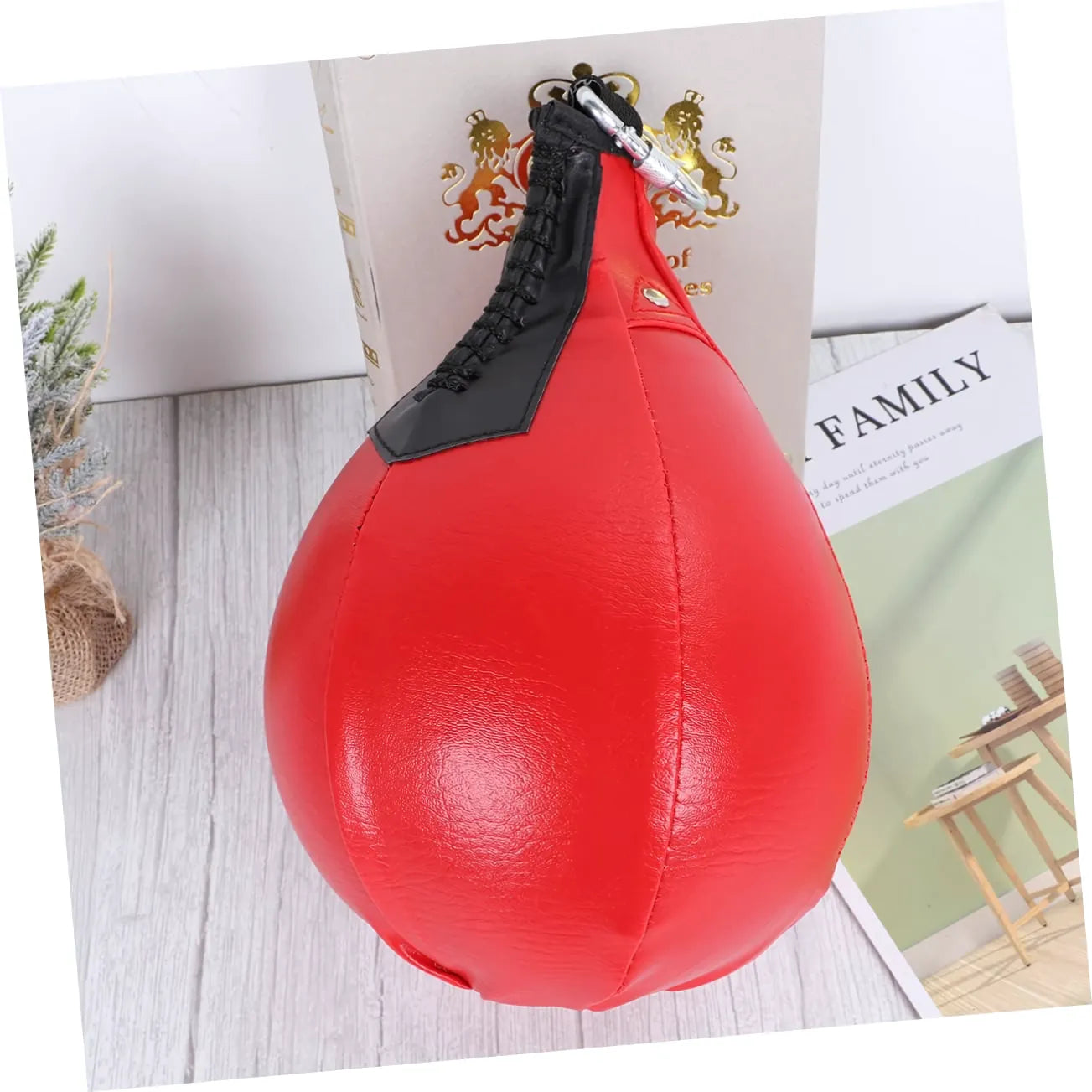 Poire de boxe gonflable en PU rouge posée sur une table.