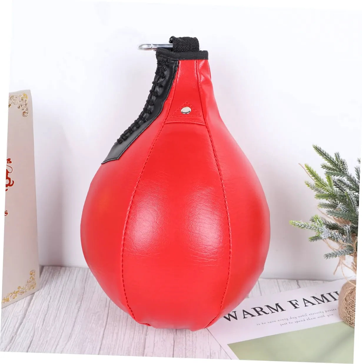 Poire de boxe gonflable en PU rouge montrée de profil avec un crochet de fixation.
