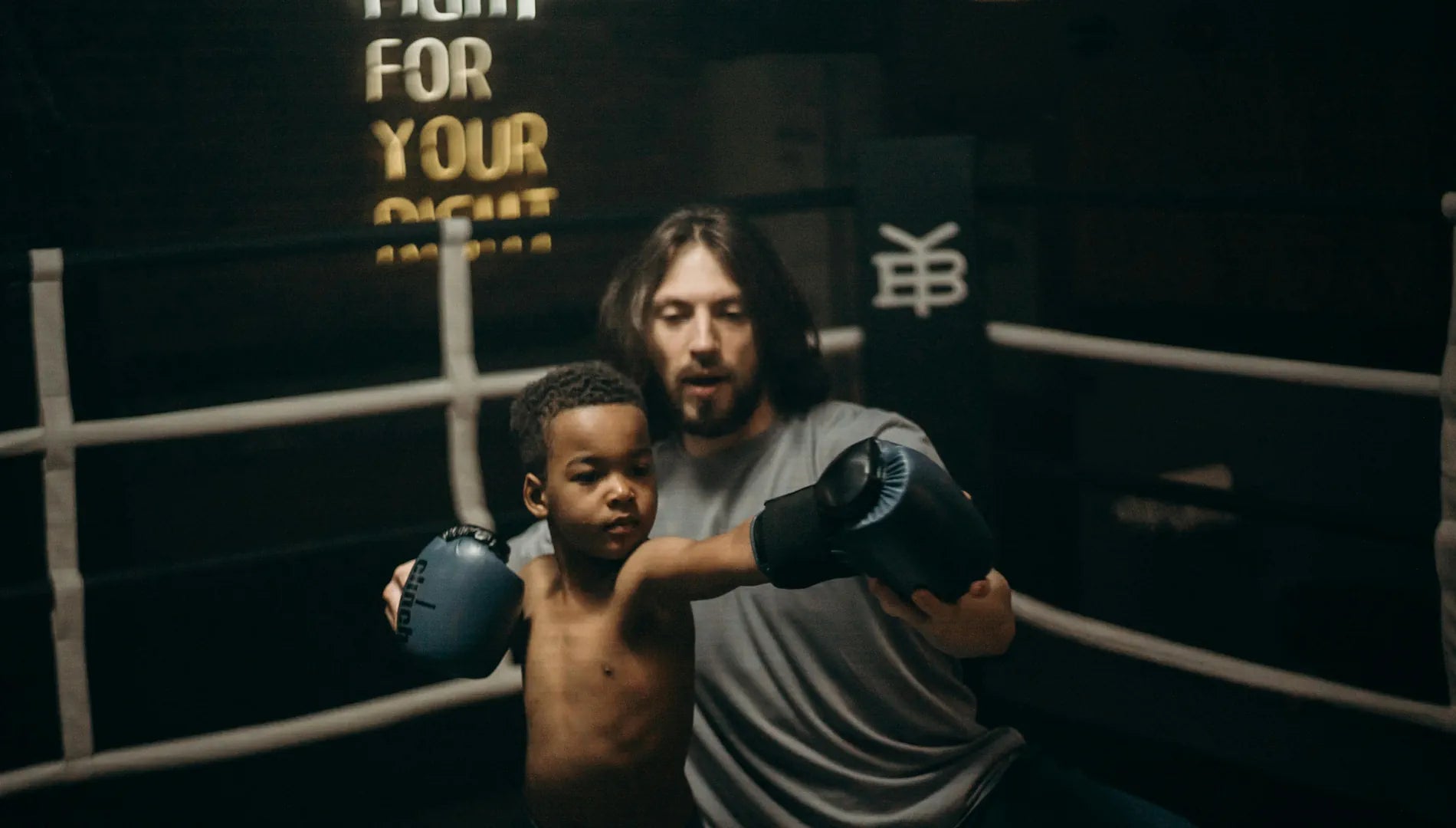 Enfant boxeur qui se fait entrainer par un coach