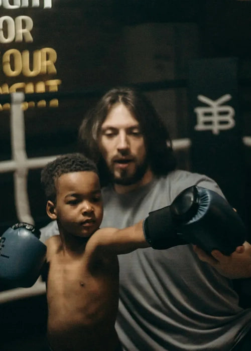 Enfant boxeur qui se fait entrainer par un coach
