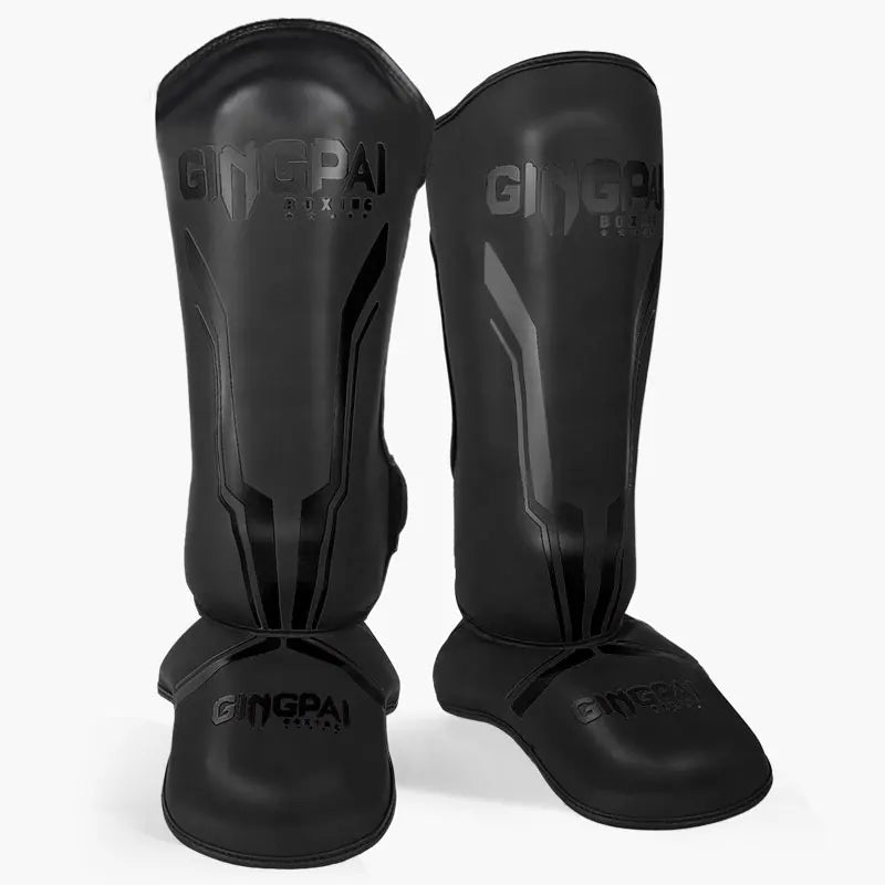 Protège-tibias de boxe GINGPAI en cuir PU noir avec inscriptions noires, vue de face