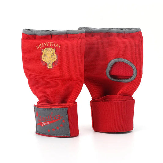 Sous-gants de boxe gel rouges avec logo doré et ouverture pour le pouce, posés à plat.