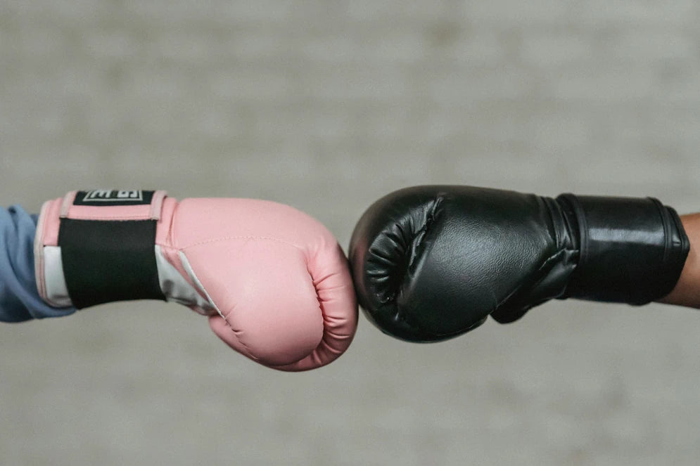 Gants de boxe rose et noir en contact pour entraînement ou combat