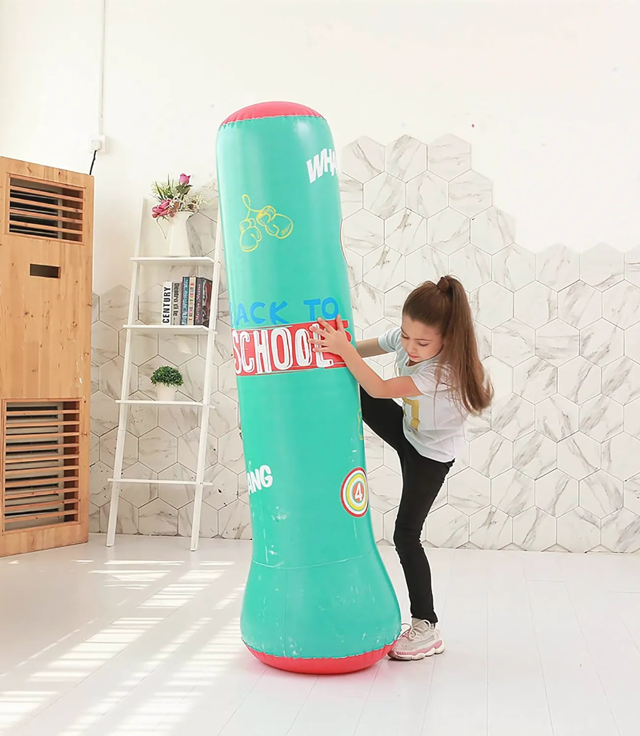 Fille jouant avec un punching ball gonflable vert Back to School.
