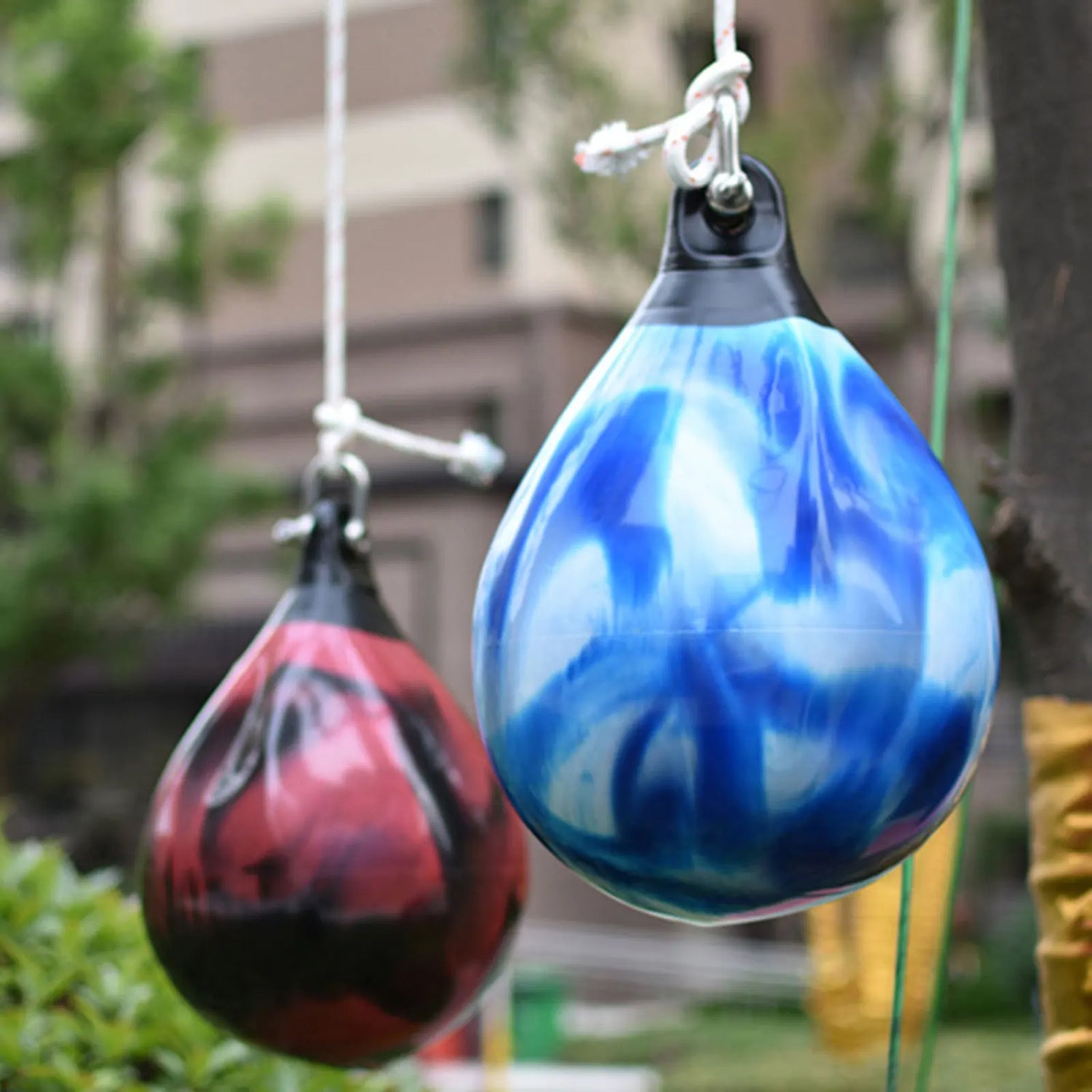 Deux sacs de frappe suspendus à remplir d'eau, couleurs bleue et rouge